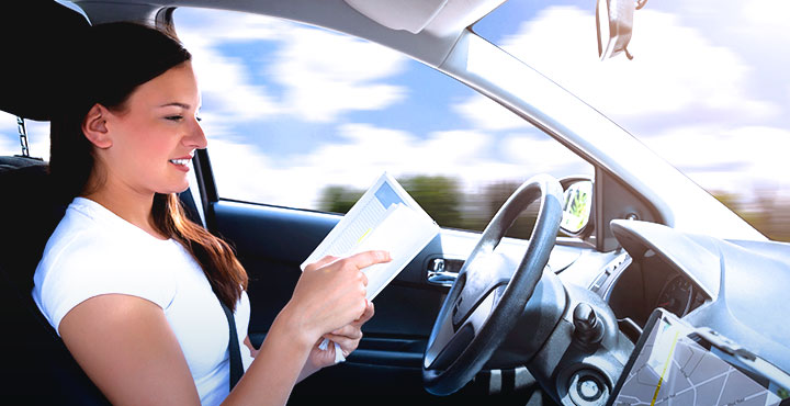Frau liest in selbstfahrendem Auto ein Buch